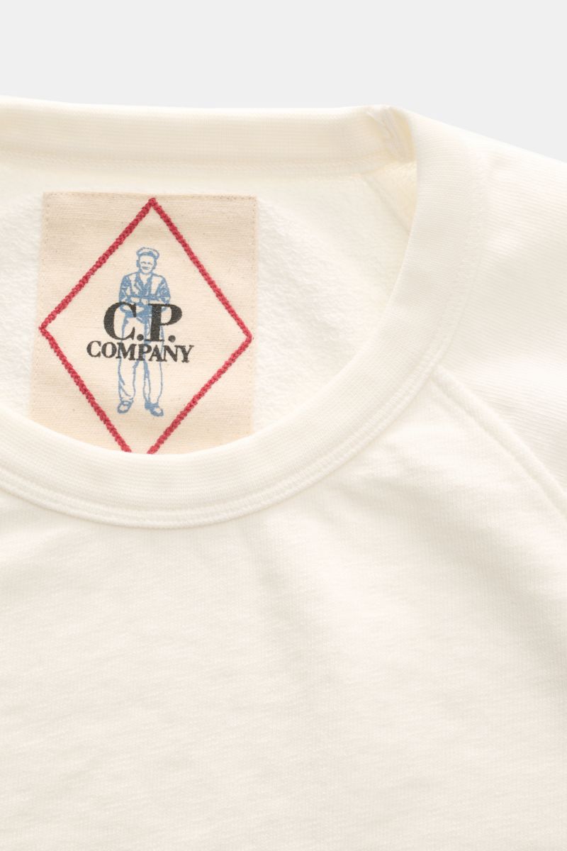 Close-up top-down view of cream crew neck and label of C.P. Company Crew neck short sleeve sweatshirt cream.

This lightweight short sleeve sweatshirt with small logo print on the front is a cool summer piece by C.P. COMPANY.

Sweatwear in 