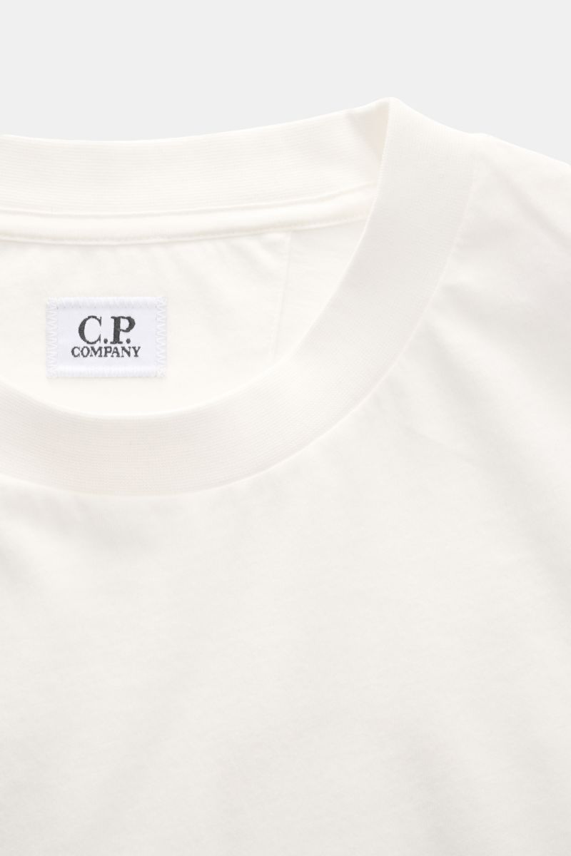 Close-up front view of C.P. Company T-shirt off-white showing crew neck and chest logo tag in pure cotton slim fit fabric.

With a distinctive logo print on the back and one on the chest, this T-shirt in pure cotton by C.P. COMPANY is a sporty must-hav