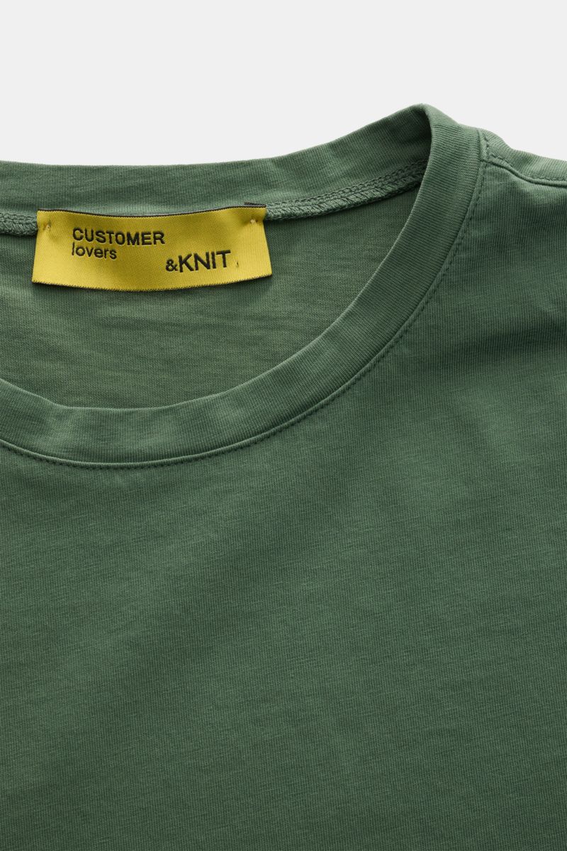 B.F. Knitwear Rundhals-T-Shirt grün, Nahaufnahme von oben, reine Baumwolle, weicher Griff, Slim Fit, Rundhalsausschnitt, kurze Saumschlitze.