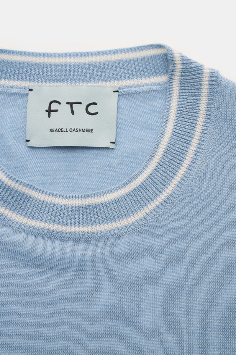Nahaufnahme des hellblauen FTC Kurzarm-Rundhalspullovers mit weißem Kontraststreifen am Rundhalsausschnitt und Label, nachhaltiger Cashmere-SeaCell-Mix.