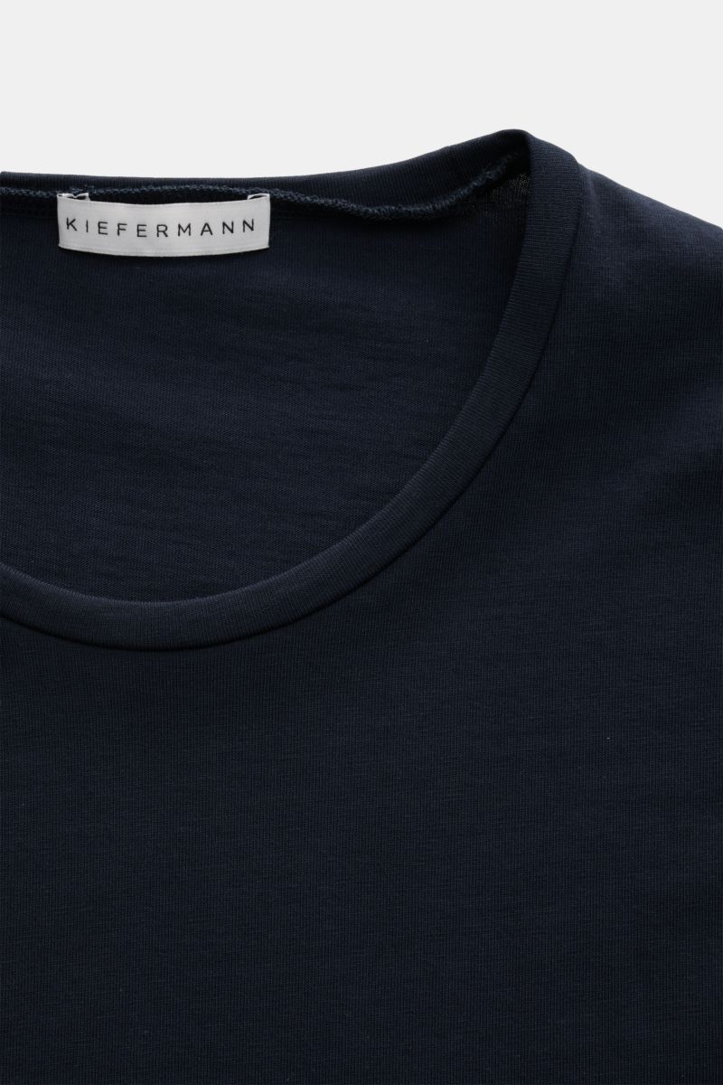 Nahaufnahme aus leichter Vogelperspektive auf das navyfarbene Kiefermann Rundhals T-Shirt 'Matello' aus weichem Baumwoll-Jersey mit Extra Slim Fit und Logodruck am Saum.