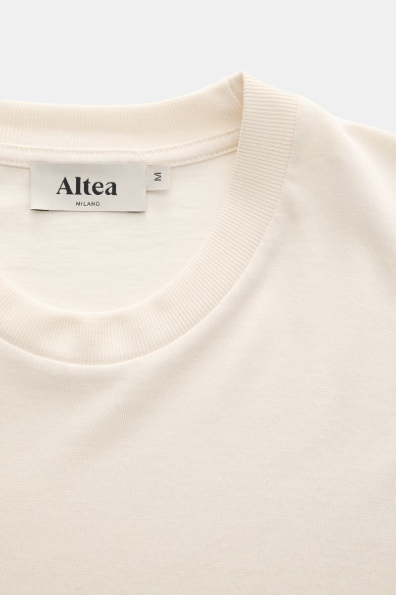 Altea Short sleeve jumper 'Cecil' cream shown from a close-up top front perspective, featuring a soft lyocell-cotton blend, very fine knit, slim fit, elasticated ribbed bands, and short hem vents. For a summery feel: The airy short sleeve jumper 'Cecil' b