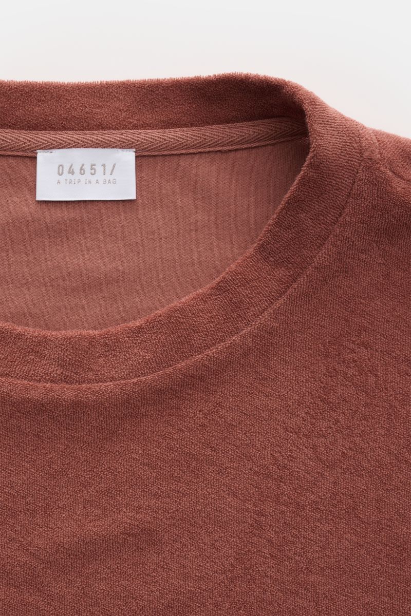 Close-up front view of 04651/ A trip in a bag Terry T-shirt 'Terry Tee' rust brown showing crew neck and soft terrycloth texture.

Description: The clean T-shirt 'Terry Tee' by 04651/ A TRIP IN A BAG is made of soft terry in pure cotton fabric and is t