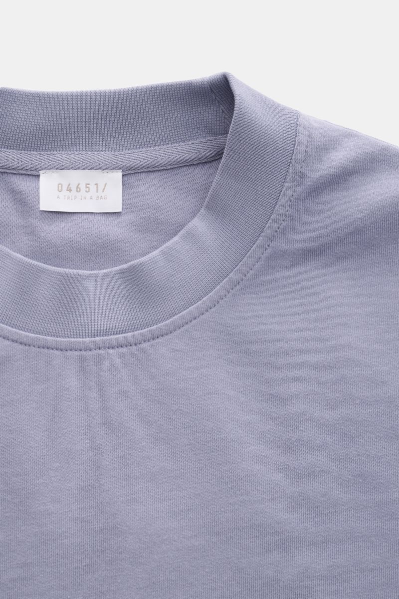 Nahaufnahme des lavenderfarbenen 04651/ A trip in a bag Rundhals-T-Shirts aus schwerem Baumwoll-Jersey mit kleinem Weblabel.