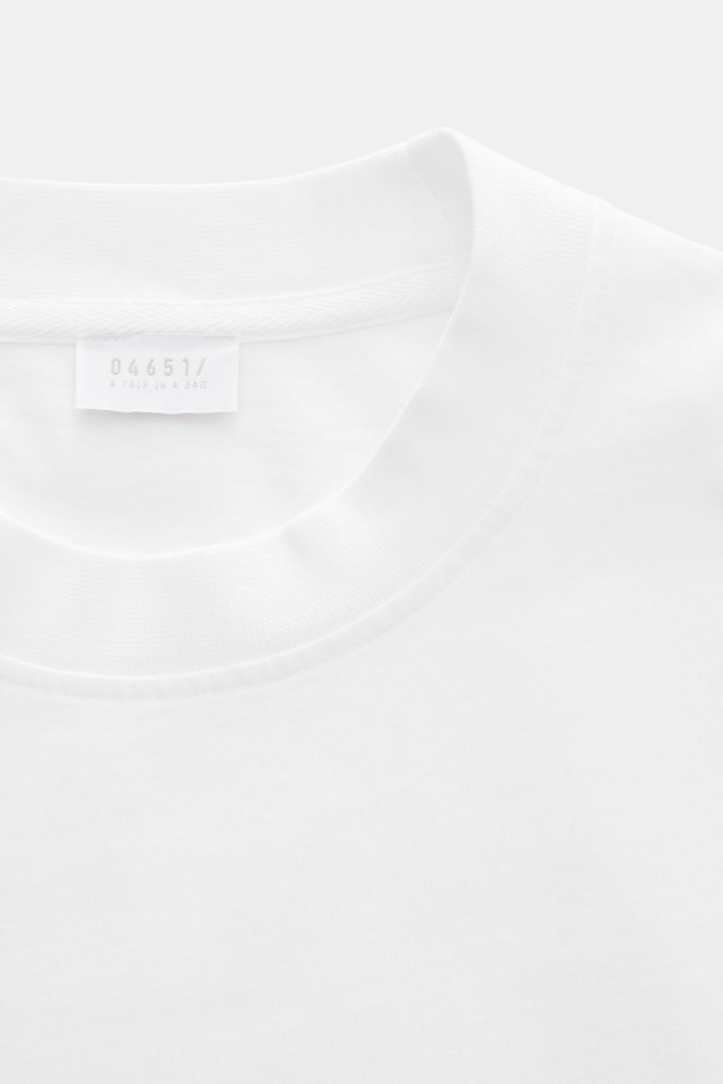 Close-up front view of 04651/ A trip in a bag T-shirt 'Nunu' white showing crew neck and label. A basic with a print accent: With its Copenhagen inspired print, this T-shirt by 04651/ A TRIP IN A BAG makes a modern statement and is the ideal piece for urb