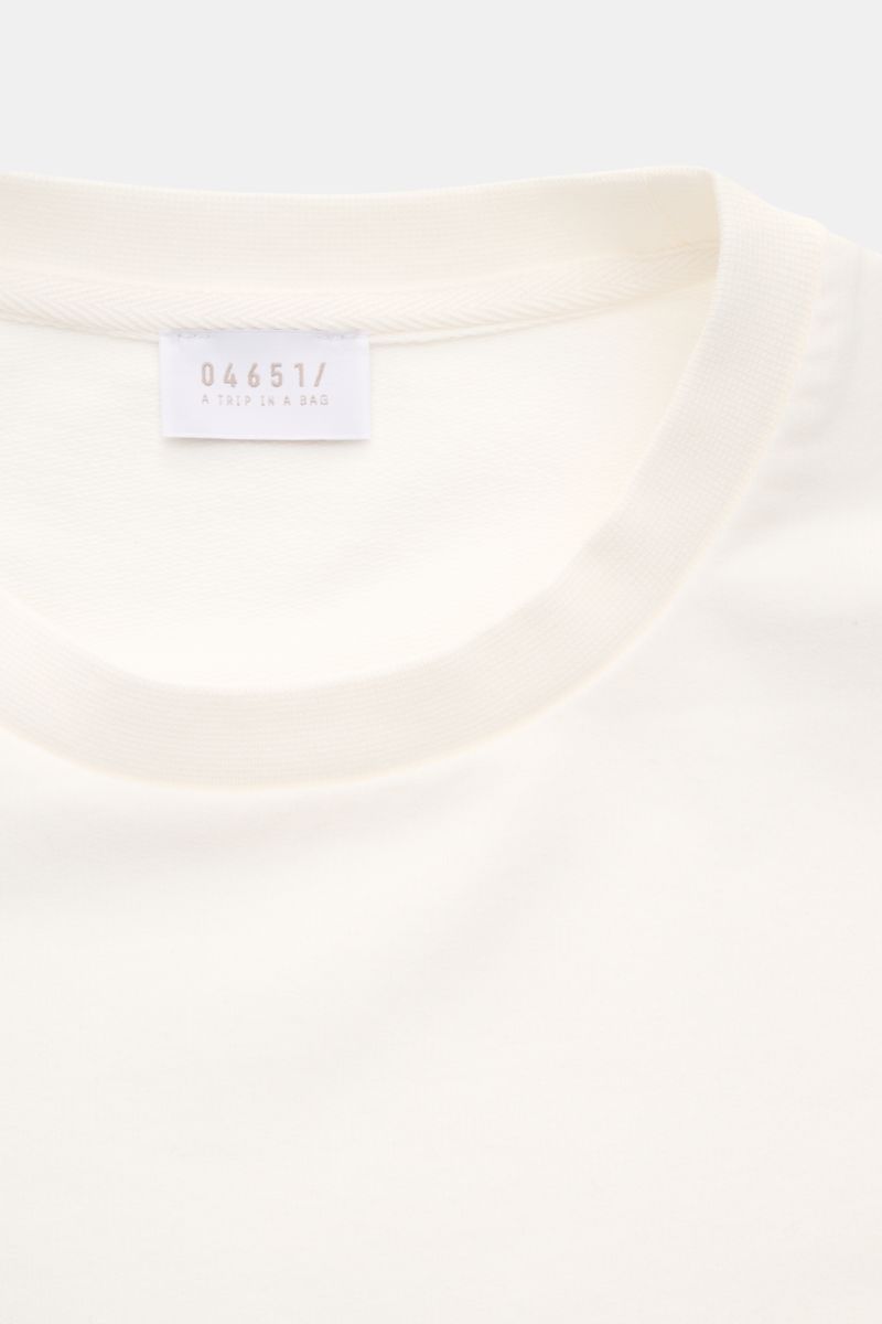 Close-up front view of the cream-colored neckline and label of the 04651/ A trip in a bag Crew neck T-shirt 'If Tee' cream. The uncomplicated cotton T-shirt 'IF Tee' by 04651/ A TRIP IN A BAG is a core basic for the new season that gives a taste of a rela