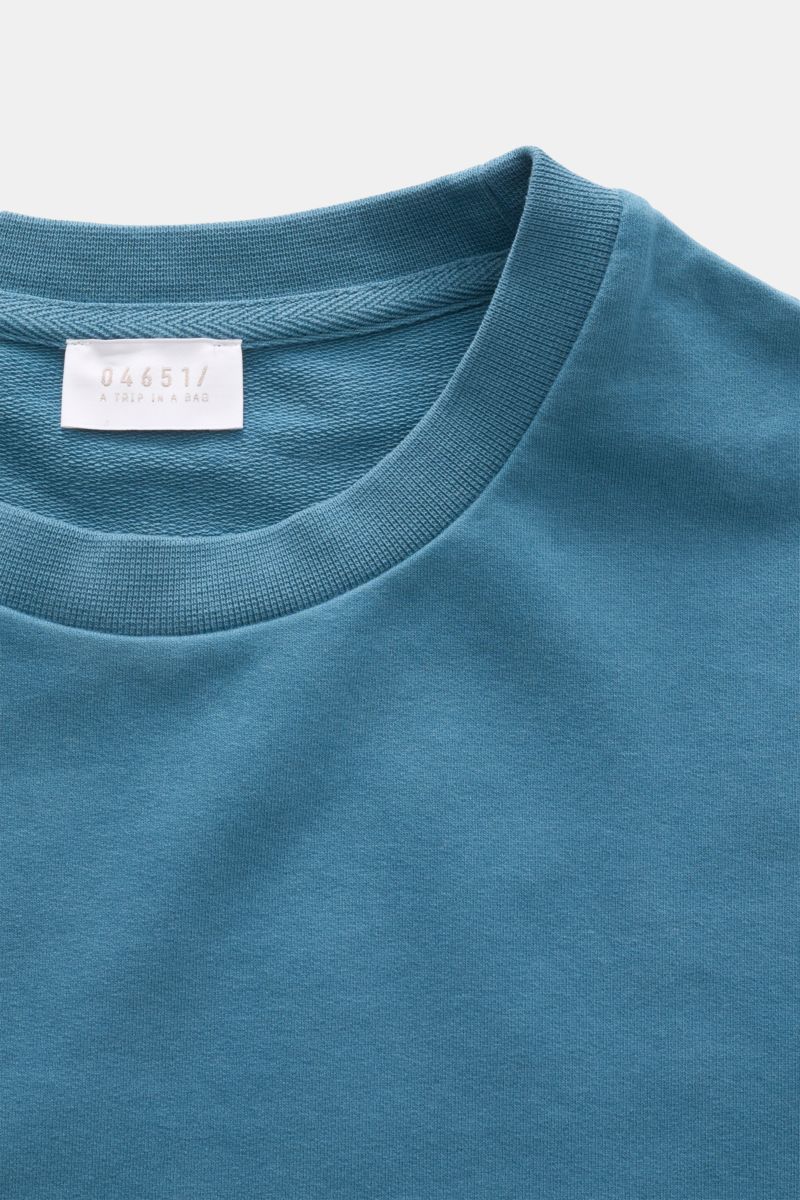 Close-up front view of 04651/ A trip in a bag Crew neck T-shirt 'If Tee' teal showing elasticated cotton jersey, soft feel, heavy fabric, oversized fit, crew neck, and woven label in side seam.