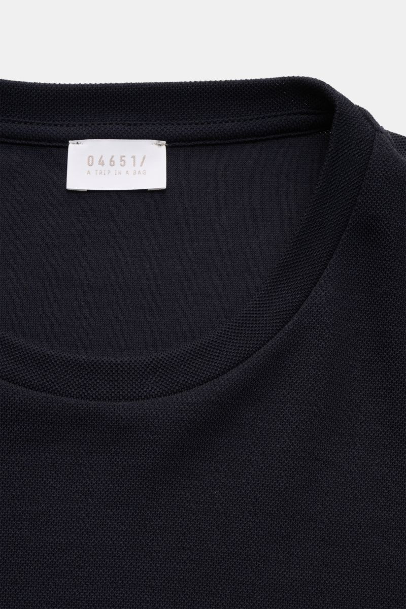 Close-up front view of the neckline and label of the 04651/ A trip in a bag Piqué-T-Shirt 'TP' navy, made of pure cotton piqué with a grainy texture.

Additional description:
Summer Essential: Das Piqué-T-Shirt von 04651/ A TRIP IN A BAG überzeugt an w