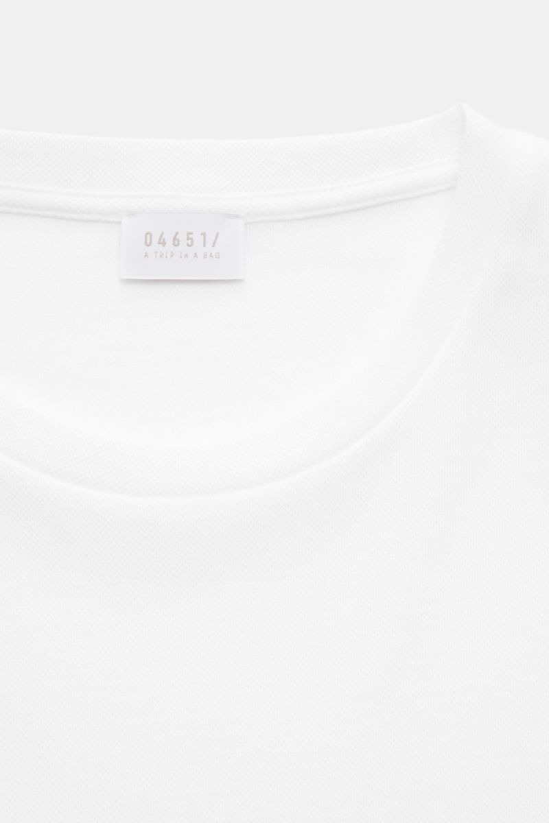 Close-up front view of the neckline and label of the 04651/ A trip in a bag Piqué-T-Shirt 'TP' weiß in white cotton piqué fabric.

Summer Essential: Das Piqué-T-Shirt von 04651/ A TRIP IN A BAG überzeugt an warmen Tagen als vielseitiges Basic.
