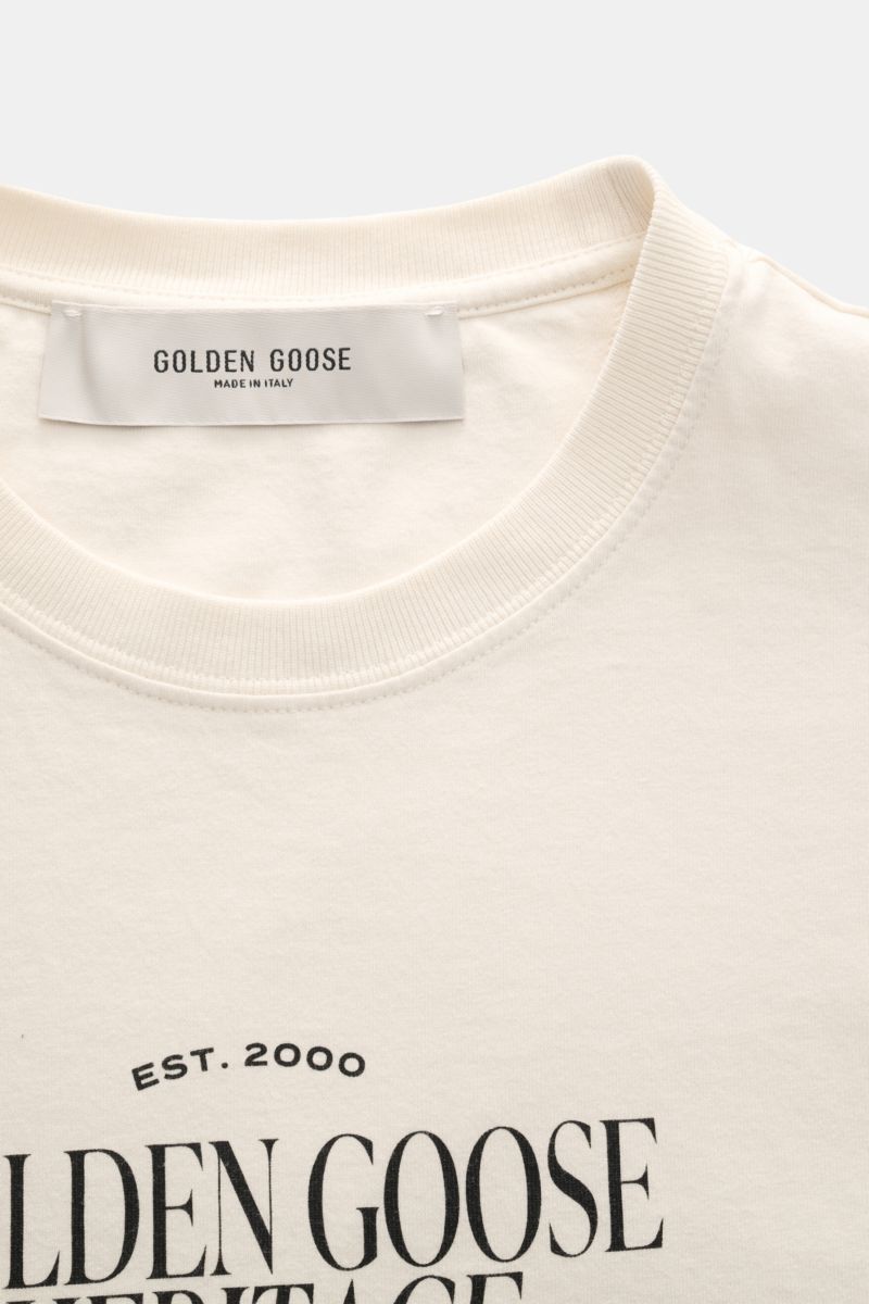 Golden Goose Rundhals-T-Shirt creme shown from a close-up front angle, featuring ribbed crew neckline and logo print.

Urbaner Eyecatcher: Das T-Shirt von GOLDEN GOOSE ergänzt Sommerlooks mit markantem Print und unverwechselbarer Lässigkeit.

