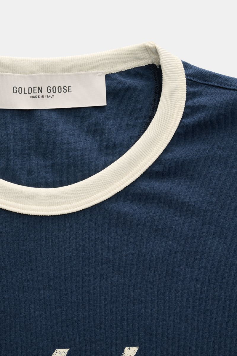 Close-up front view of Golden Goose Rundhals-T-Shirt navy/creme with cream round neckline and visible brand label.

Retro-Sportswear neu interpretiert: Das T-Shirt von GOLDEN GOOSE sorgt mit markantem Print für legere Sommerlooks.

reine Ba