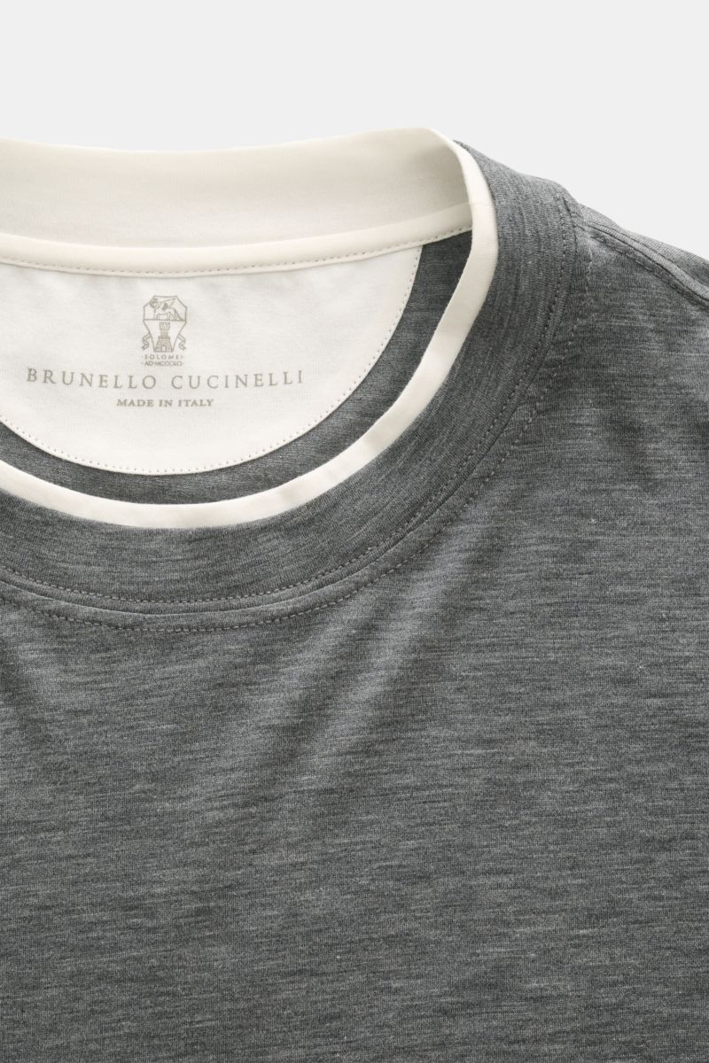 Close-up front view of Brunello Cucinelli Rundhals-T-Shirt dunkelgrau meliert/creme showing the round neckline with contrast double hem.

BRUNELLO CUCINELLI liefert mit diesem legeren T-Shirt aus luxuriöser Seiden-Baumwollmischung ein unverzichtbares B