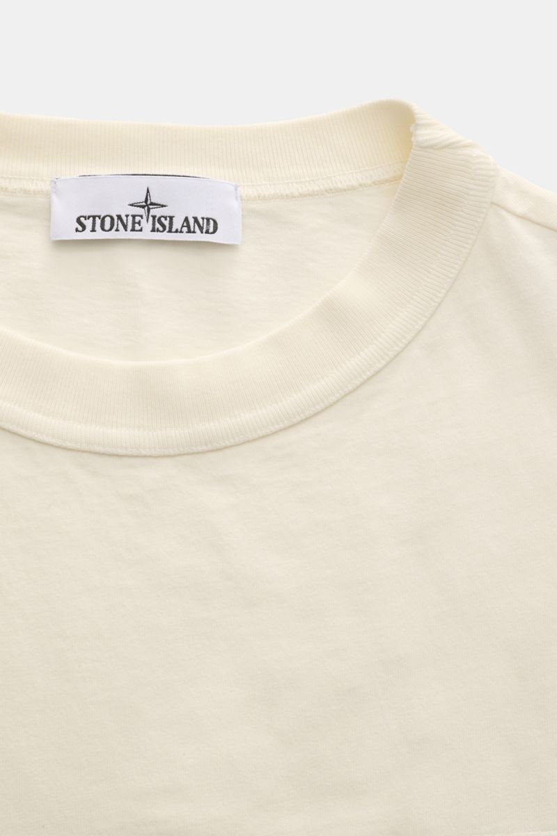 Stone Island Rundhals-Longsleeve off-white, Nahaufnahme von oben, Jersey aus reiner Bio-Baumwolle, weicher Griff, garment dyed, Regular Fit, Rundhalsausschnitt, STONE ISLAND Weblabel auf der Brust, elastische Ärmelbündchen.
