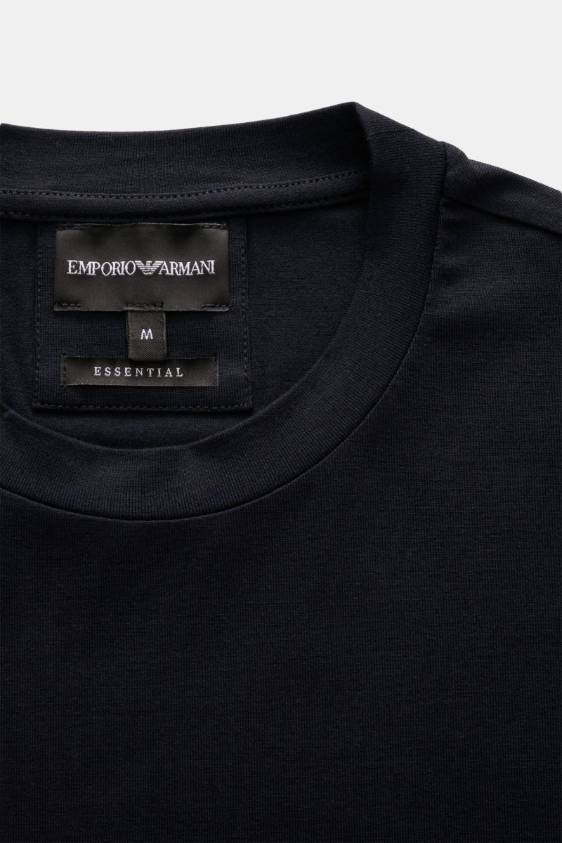 Close-up view of the Emporio Armani Crew neck T-shirt navy showing the crew neck and brand label inside the collar, made of smooth viscose jersey with a slim fit and rubberised logo on the hem.

Description: This clean T-shirt with crew neck by EMPORIO