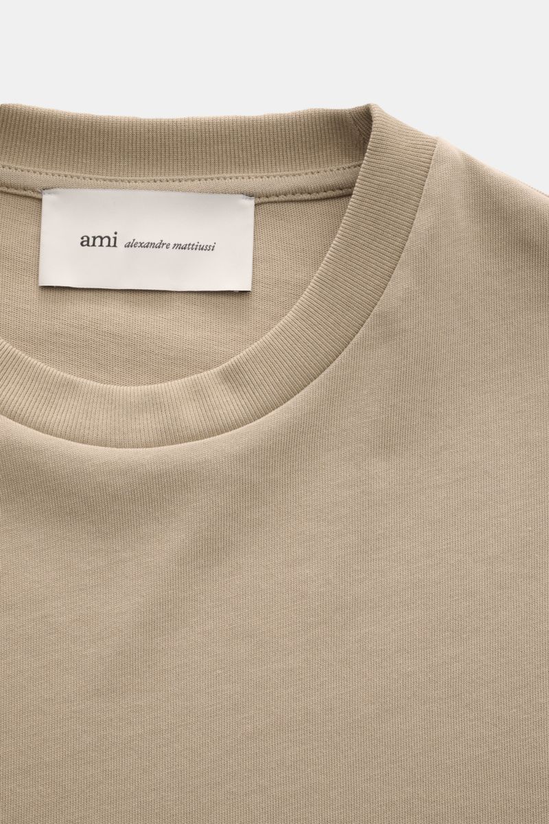 Close-up front view of Ami Paris Long sleeve taupe showing the crew neck and label with ami alexandre mattiussi branding.

Create perfect urban looks with this long sleeve by AMI PARIS – the quilted seams and signature heart logo on the hem make it an 
