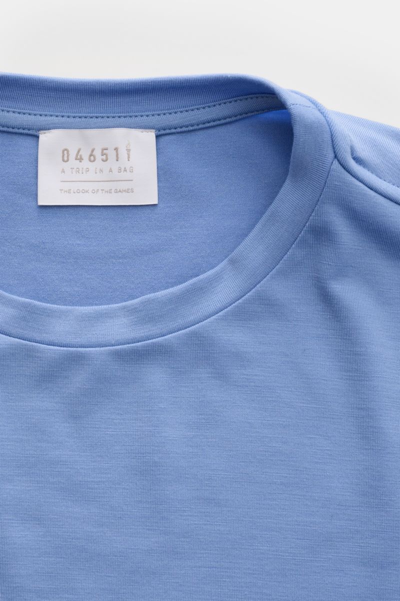 04651/ A trip in a bag Merino Longsleeve rauchblau, von oben fotografiert, zeigt Rundhalsausschnitt, elastische Merinowolle, weicher Griff, Regular Fit, kurze Saumschlitze, vielseitiges Basic aus der 'Look of the Games' Capsule 2026.