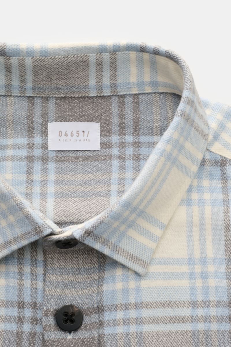 Close-up front view of the 04651/ A trip in a bag Overshirt 'Check Overshirt' off-white/light blue/grey checked, showing the turn-down collar, six-button placket, and soft pure cotton in a modern checked pattern. Stay casual through the transitional perio