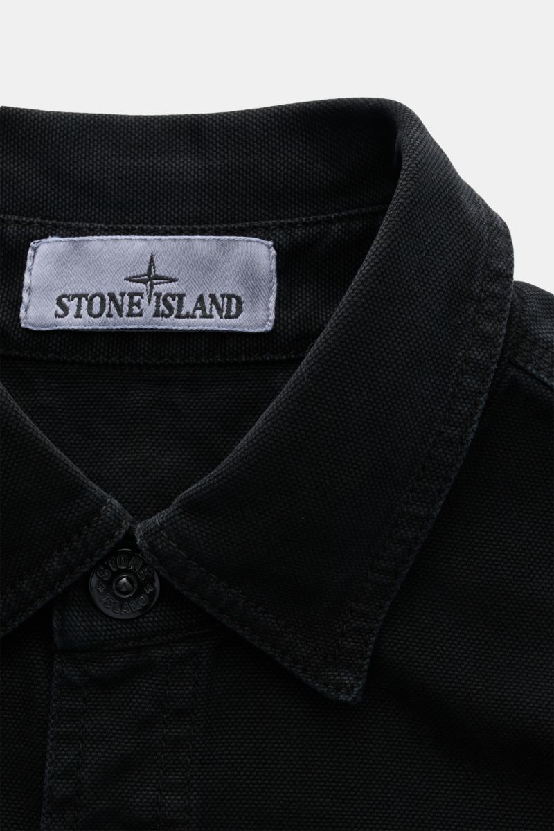 Close-up front view of Stone Island Overshirt 'Organic Panama' schwarz collar and top button, made of pure cotton with soft texture and slim fit.