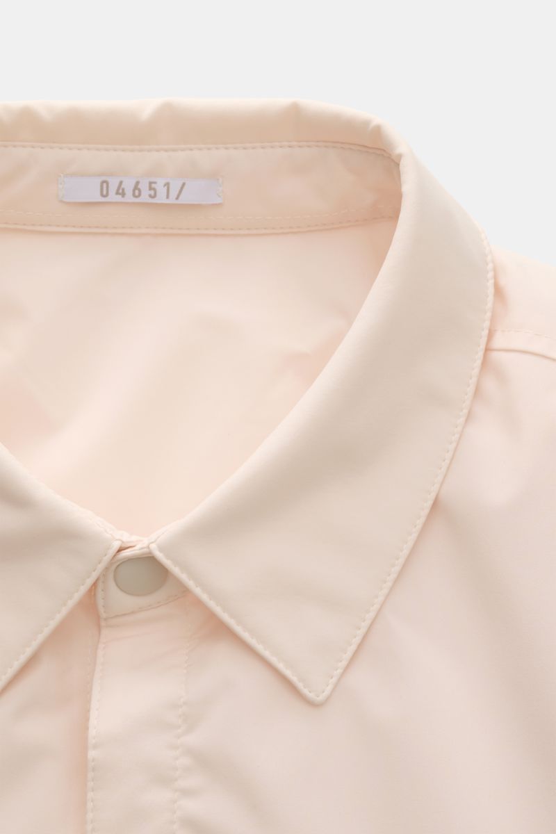 Nahaufnahme von Kragen und Knopfleiste des cremefarbenen 04651/ A trip in a bag Overshirt 'Travel', wind- und wasserabweisend mit leichter Wattierung.