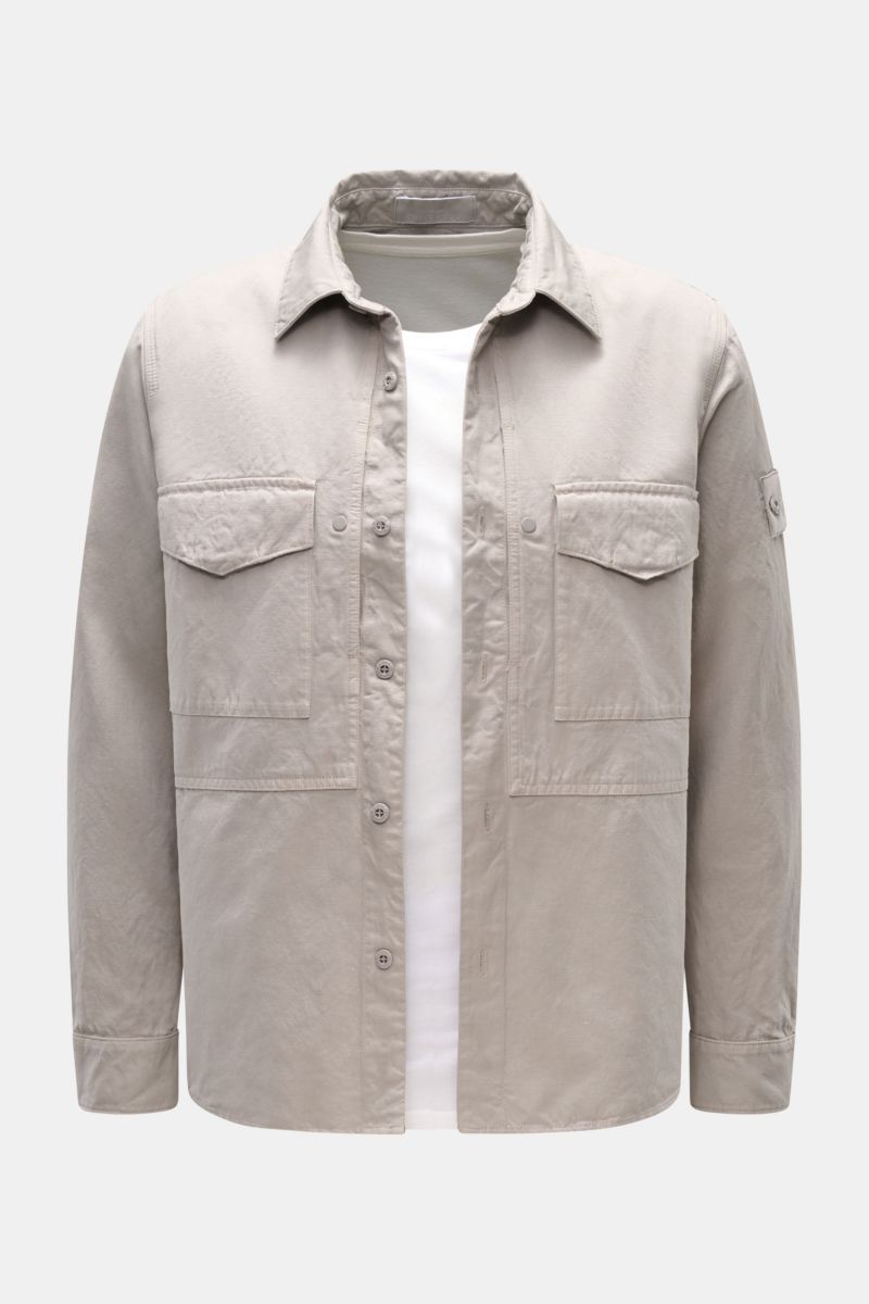 Stone Island Overshirt 'Ghost' light grey shown from the front, featuring a cotton and linen blend slim fit with six-button placket, turn-down collar, three front pockets, button cuffs, compass badge on the upper sleeve, and an unconstructed design. Timel