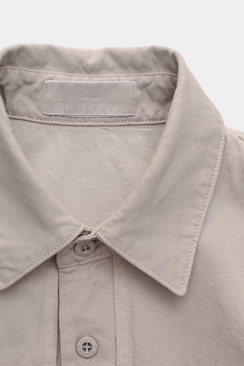Stone Island Overshirt 'Ghost' light grey close-up from above showing the turn-down collar, six-button placket, and fabric texture. Timeless layering piece: This overshirt from the 'Ghost' capsule by STONE ISLAND perfectly enhances casual spring looks. Co