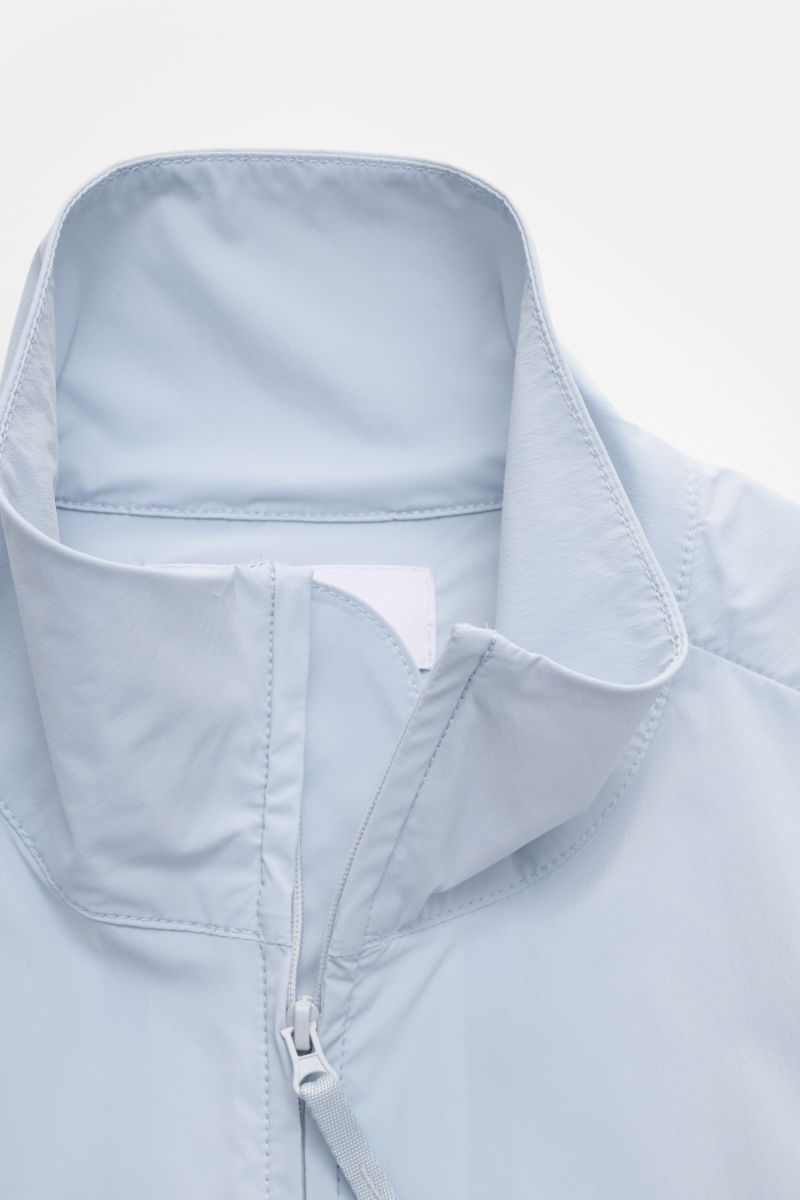 Stone Island Jacke 'Stellina' hellblau aus Microfaser, Regular Fit, mit Zwei-Wege-Reißverschluss, Zipper-Fronttaschen, elastischen Ärmelbündchen, unconstructed Design, regulierbarer Saumweite, fotografiert aus Nahaufnahme von oben.