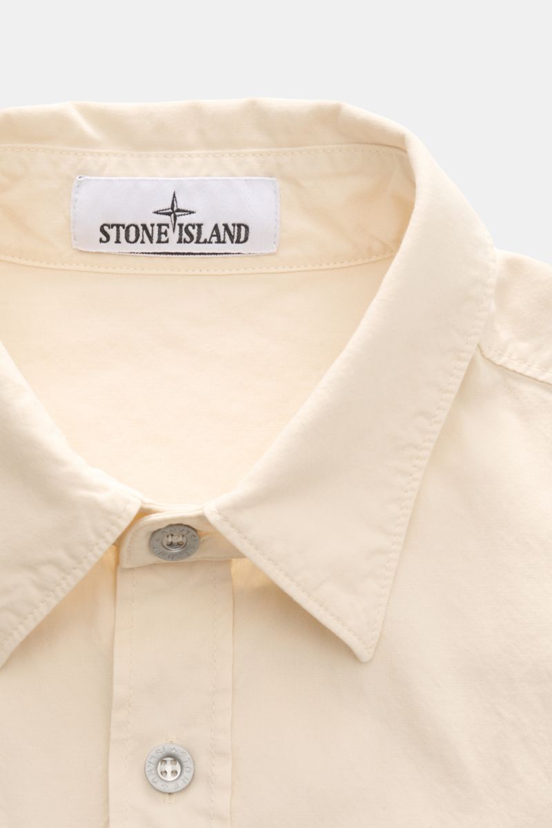 Nahaufnahme des Kragens und der Sechs-Knopf-Leiste des Stone Island Overshirt 'Marina' creme aus Baumwoll-Panama mit weichem Griff.