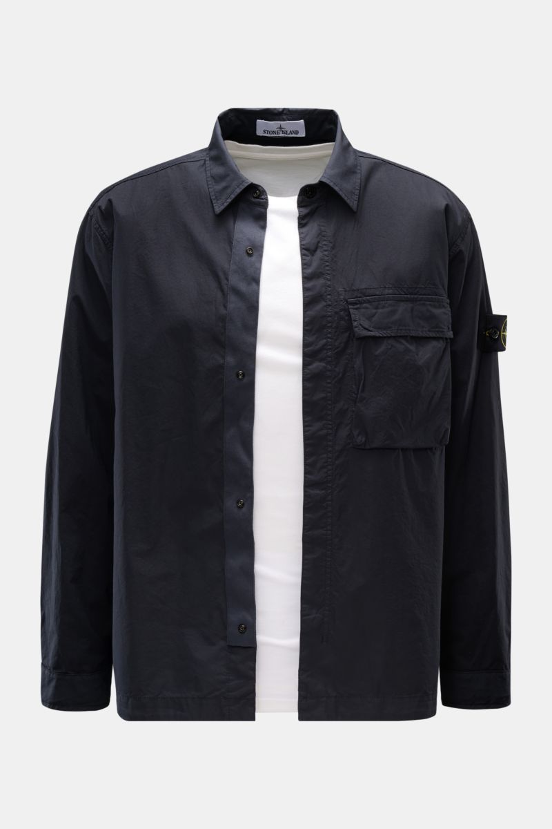 Front view of a Stone Island Overshirt navy in slim fit, made of elastic cotton with soft touch, featuring a concealed snap button placket, turn-down collar, chest patch pocket, compass badge on the upper arm, and buttoned sleeve cuffs. Vielseitiges Essen
