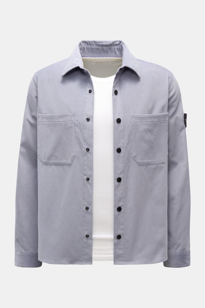 Stone Island Cord Overshirt rauchblau, frontal fotografiert, Slim Fit Cord aus Bio-Baumwolle, Druckknopfleiste, Brusttaschen, Kompass-Badge am Ärmel.