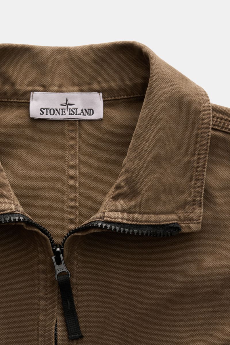 Close-up front view of the Stone Island Overshirt 'Panama' khaki showing its collar, robust two-way zipper, and textured pure cotton fabric. Vielseitiges Layering-Piece: Das zeitlose Overshirt von STONE ISLAND überzeugt mit seinem legeren Design und wird 