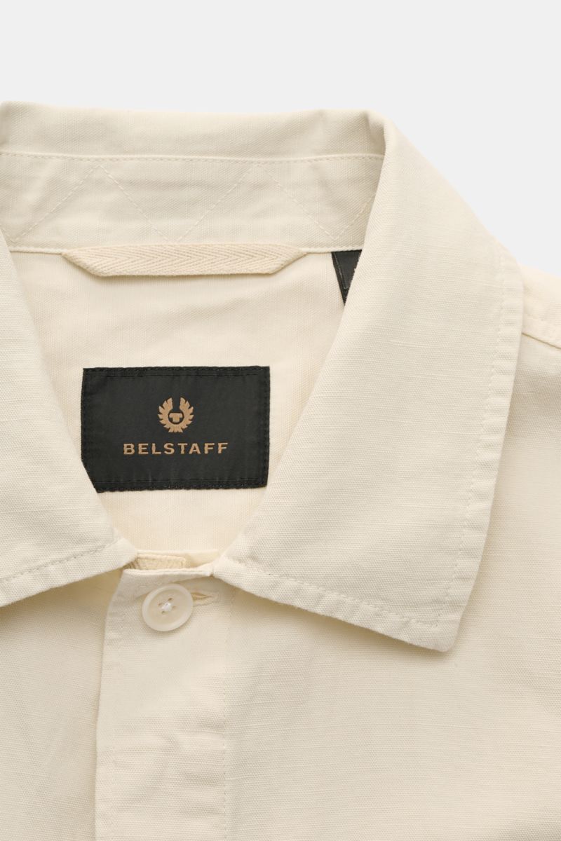 Close-up front view of Belstaff Overshirt 'Maritime' sand showing narrow collar, concealed button placket, and black Belstaff label inside collar in a cotton-linen blend with slim fit and classic details.