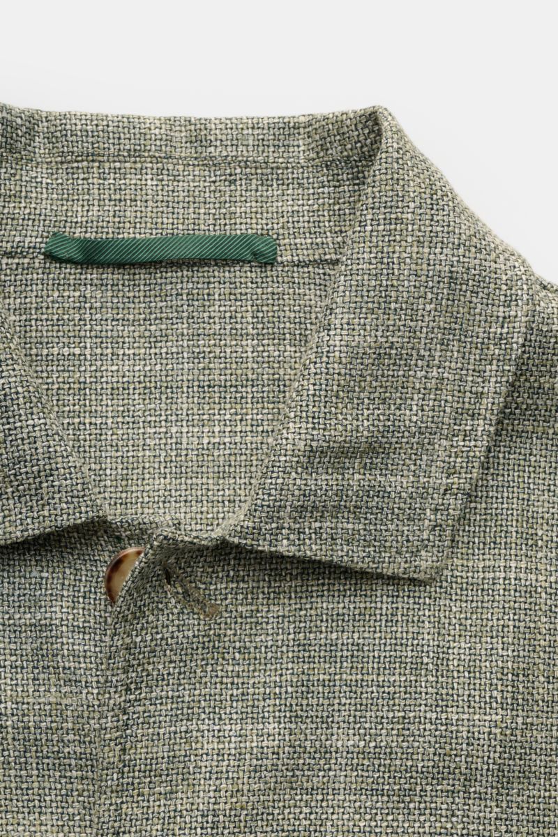 Close-up front view of the Stile Latino Overshirt 'Gu Texas' dark green/off-white mottled, showcasing its wool, silk and linen blend fabric, five-button placket, and turn-down collar.  
Luxurious layers: This sophisticated overshirt by STILE LATINO com