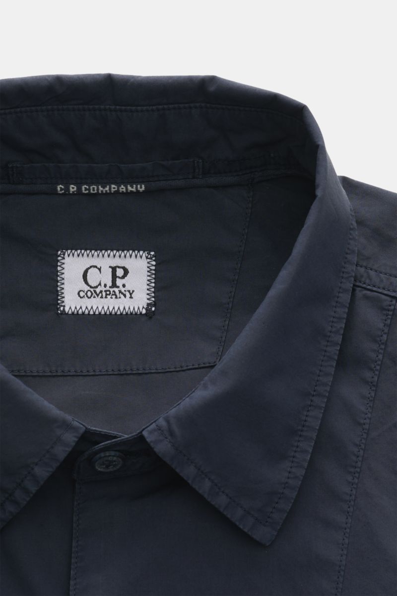 Nahaufnahme des Umlegekragens vom C.P. Company Overshirt navy aus reiner Baumwolle in Slim Fit, fotografiert von oben.
