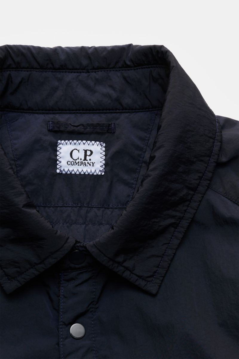 Close-up front view of C.P. Company Overshirt dark navy showing turn-down collar, snap button placket, and fabric texture, perfect for changeable spring weather with high-quality microfibre, slim fit, patch breast pocket, side seam pockets, cuffs with but
