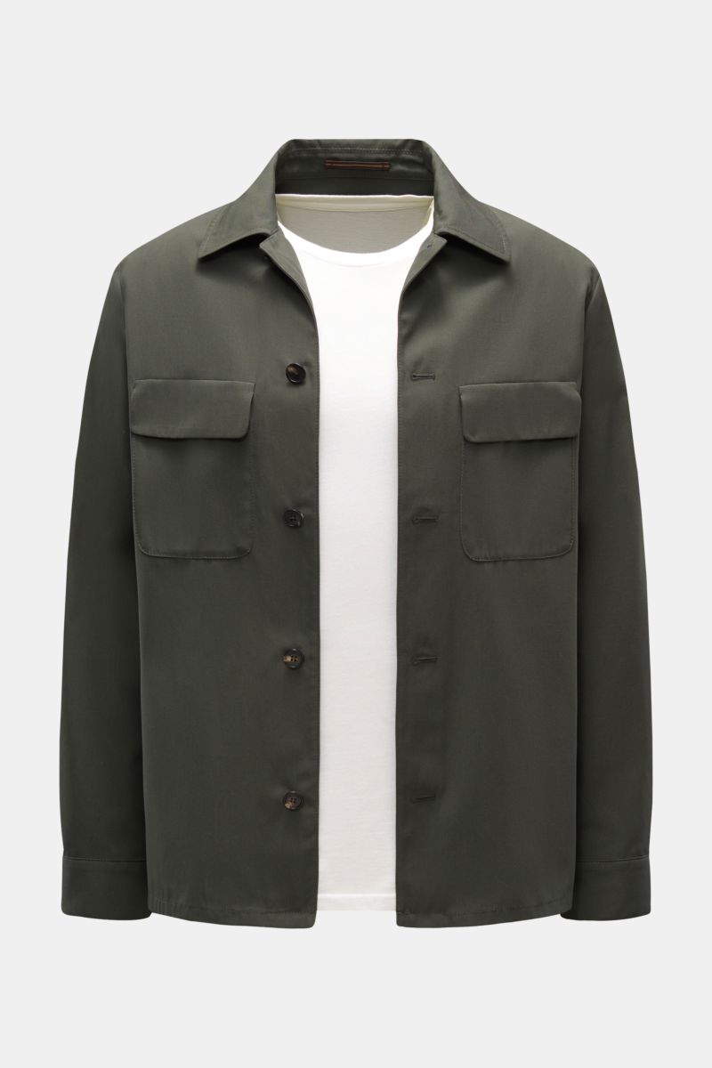 Front view of Incotex Overshirt olive in pure cotton twill with flap breast pockets, horn buttons, turn-down collar, unlined, regular fit, worn over a white T-shirt. 

Workwear charm meets modern urban ease: This unlined overshirt in pure cotton twill 