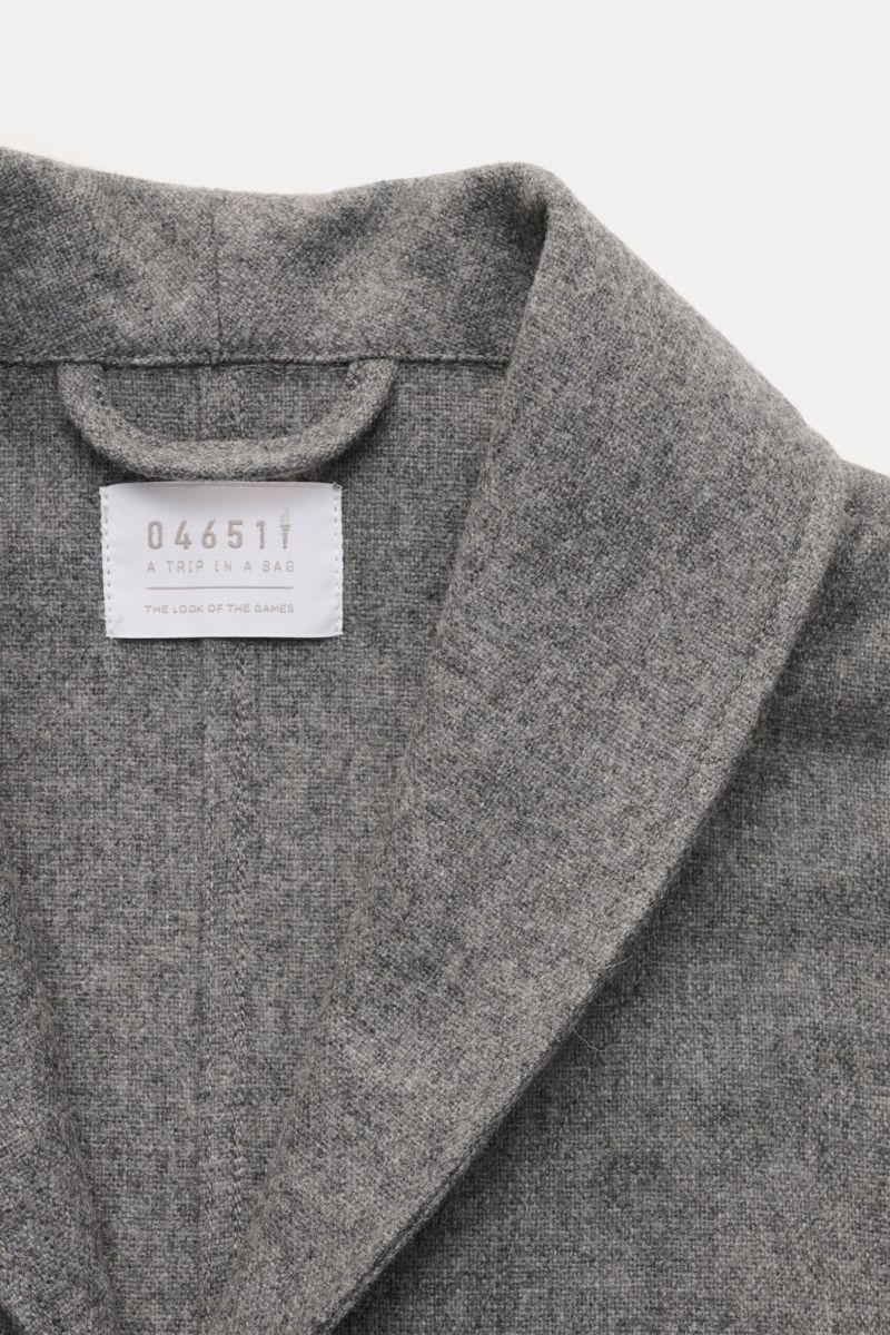 Close-up front view of the 04651/ A trip in a bag Overshirt dunkelgrau meliert showing soft wool blend fabric, shawl collar, and label inside collar. Stilvoll durch die Übergangszeit: Das Overshirt aus der 'Look of the Games' Capsule von 04651/ A TRIP IN 