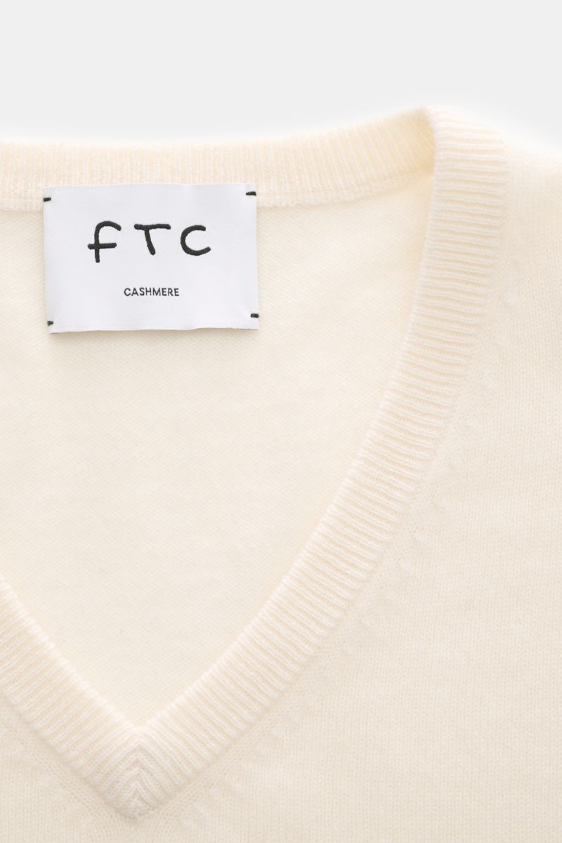FTC Cashmere V-Neck Pullover offwhite, Nahaufnahme von V-Ausschnitt und Label, Slim Fit, Fair-Trade-Cashmere, weicher Griff, feines Strickbild, Rippbündchen.