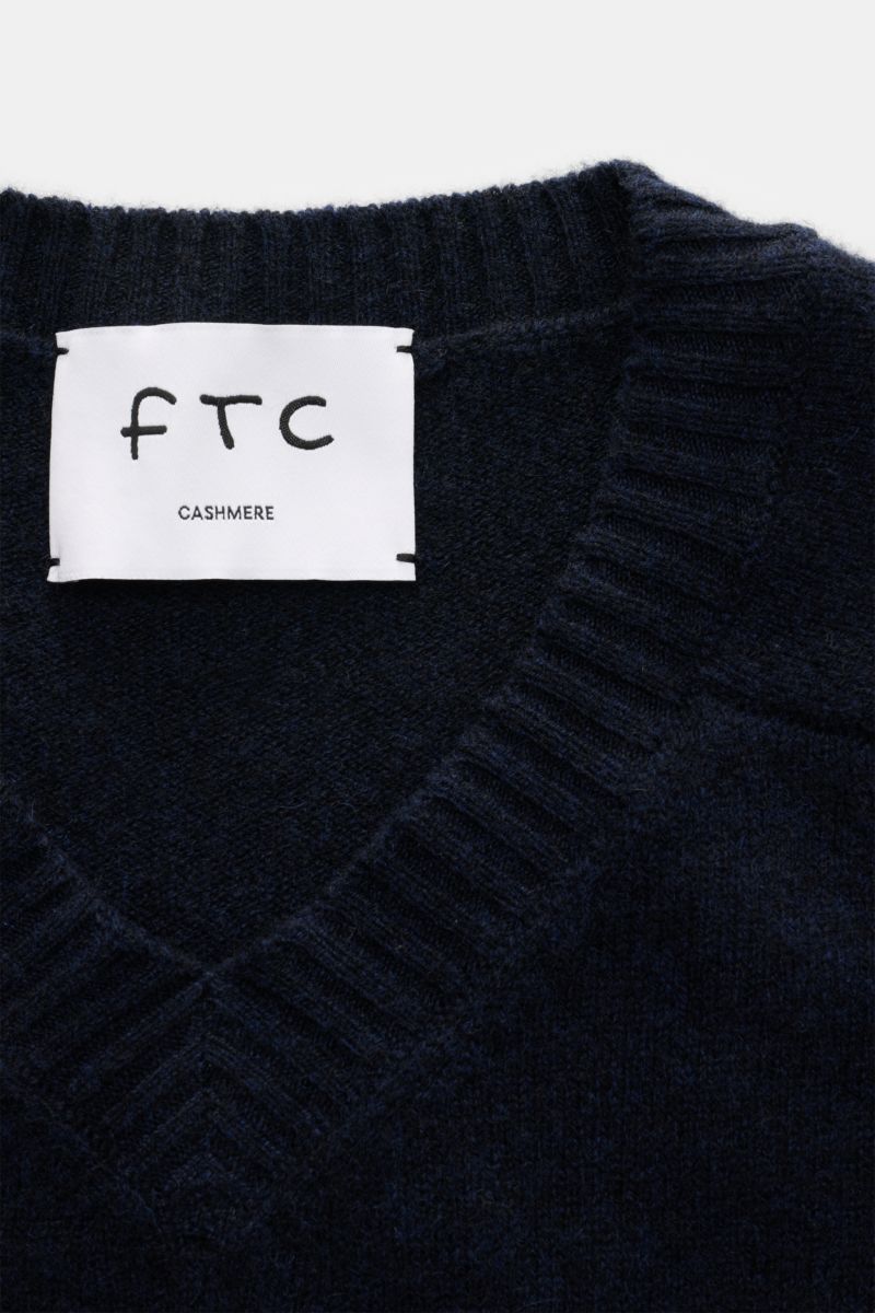 Nahaufnahme des FTC Cashmere V-Neck-Pullover navy mit V-Ausschnitt, mittelfeinem Strickbild, Rippbündchen, Fair-Trade-Cashmere, OEKO-TEX®, hohem Stretch und weichem Griff.