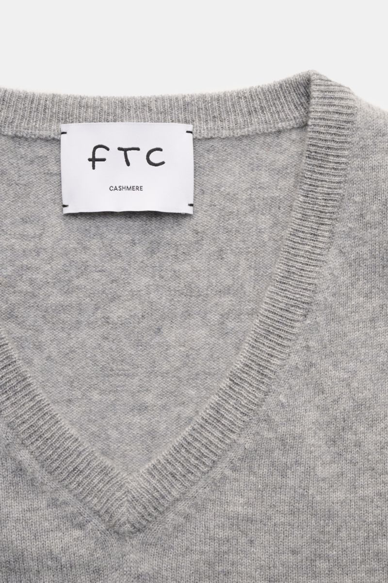 Nahaufnahme des grauen FTC Cashmere V-Neck Pullovers von oben, fein gestrickt, Slim Fit, V-Ausschnitt mit Rippbündchen, Fair-Trade-Cashmere.