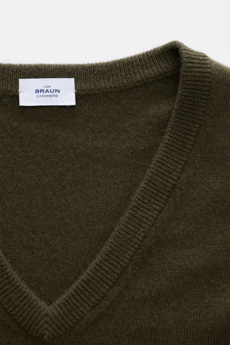 Nahaufnahme, schräg von oben, von Braun Cashmere V-Neck Pullover dark olive mit V-Ausschnitt, feinem Strickbild und elastischen Rippbündchen.