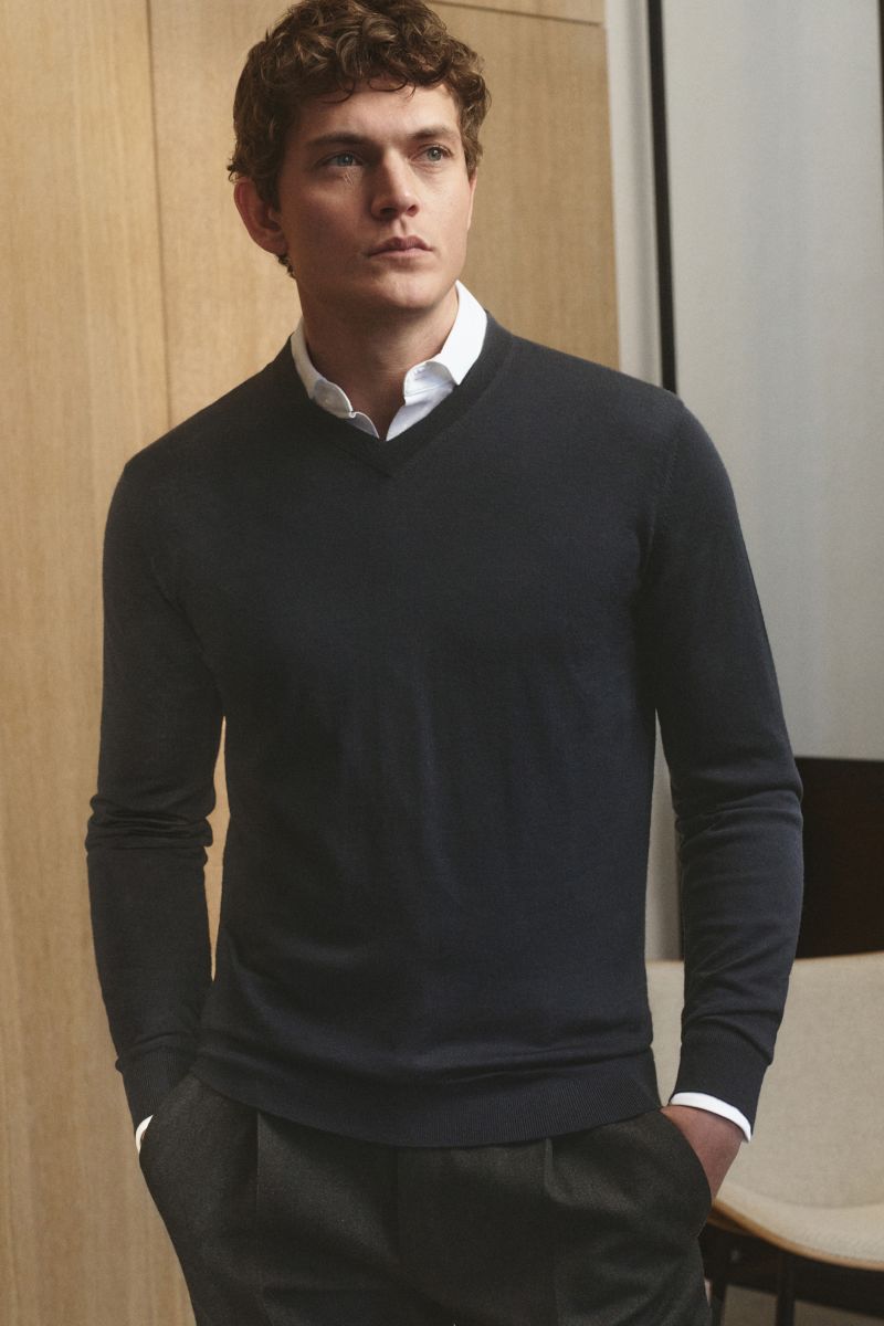 Mann frontal mit Händen in Taschen trägt von Braun Merino V-Neck Pullover navy aus feinem Merinowolle-Feinstrick, Slim Fit, V-Ausschnitt.