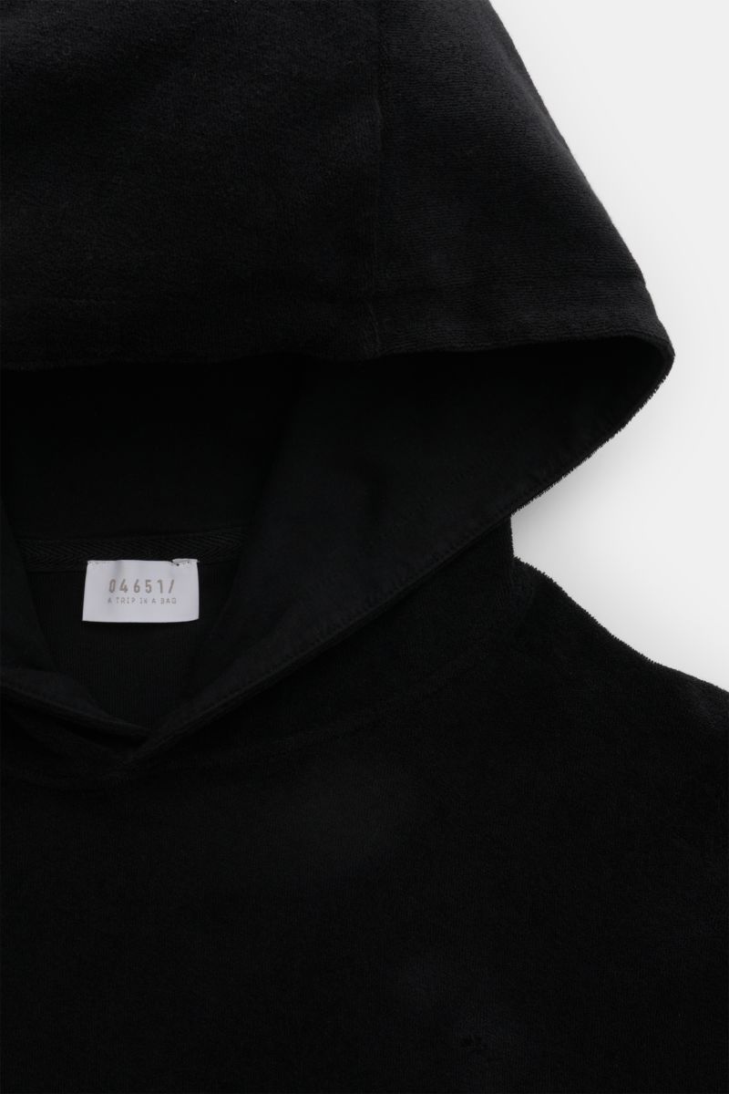 Close-up, top-down view of the black 04651/ A trip in a bag Terry hooded jumper 'Terry' made of soft pure cotton terrycloth with a practical hood and woven label.

Description: Comfort and coolness with summery nonchalance: The hooded jumper 'Terry' by