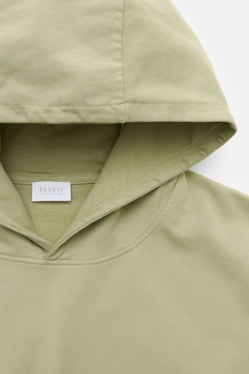 Close-up front view of 04651/ A trip in a bag Hooded jumper 'IF Hoodie' sage in stretchy brushed cotton with practical hood, ribbed bands, and small woven label.