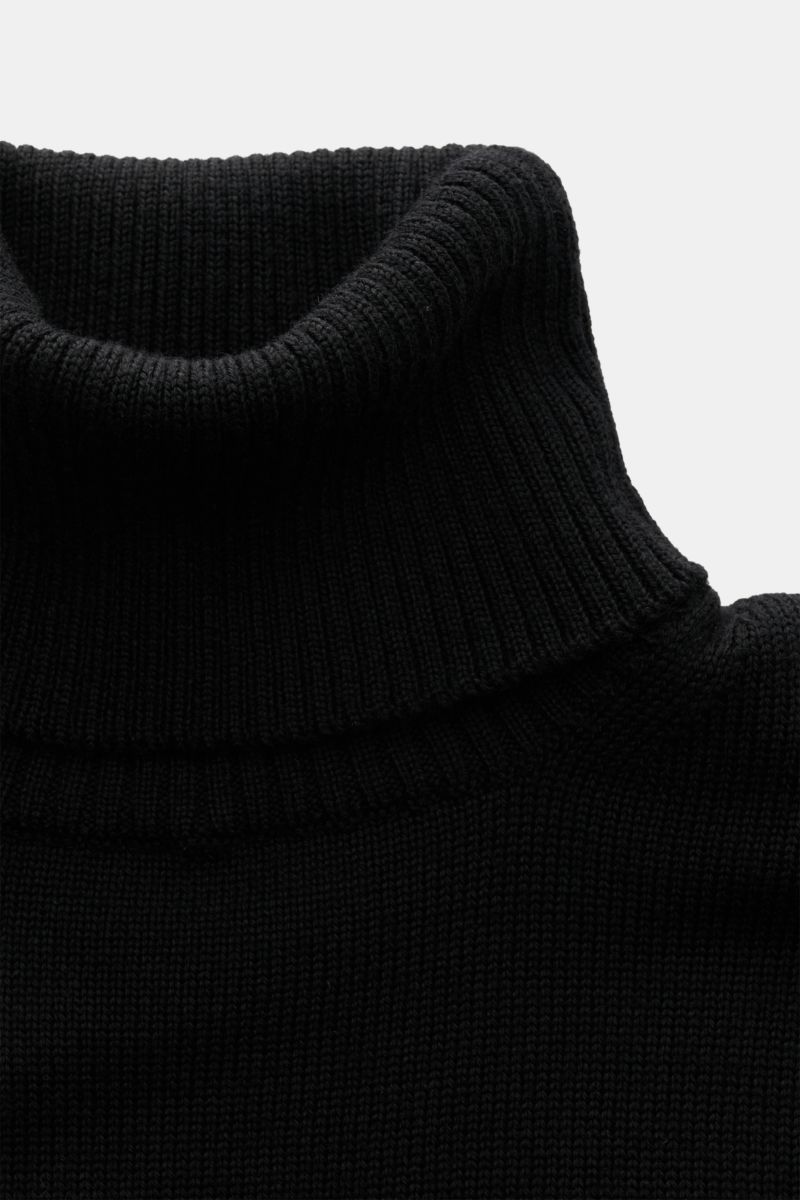 B.F. Knitwear Merino Rollkragenpullover schwarz in Slim Fit, nah fotografiert, weiche Merinowolle, mittelfeines Strickbild, anliegender Rollkragen.