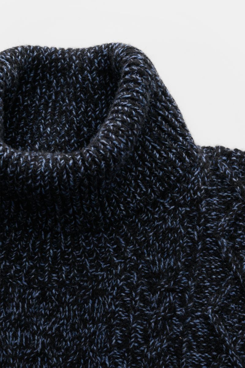 Close-up front view of 04651/ A trip in a bag Turtleneck jumper 'Mouline Cable Turtle' navy melange showing ribbed turtleneck and coarse cable knit.

Luxurious comfort in a modern design for cold winter days – the turtleneck jumper 'Mouline Cable Turtl
