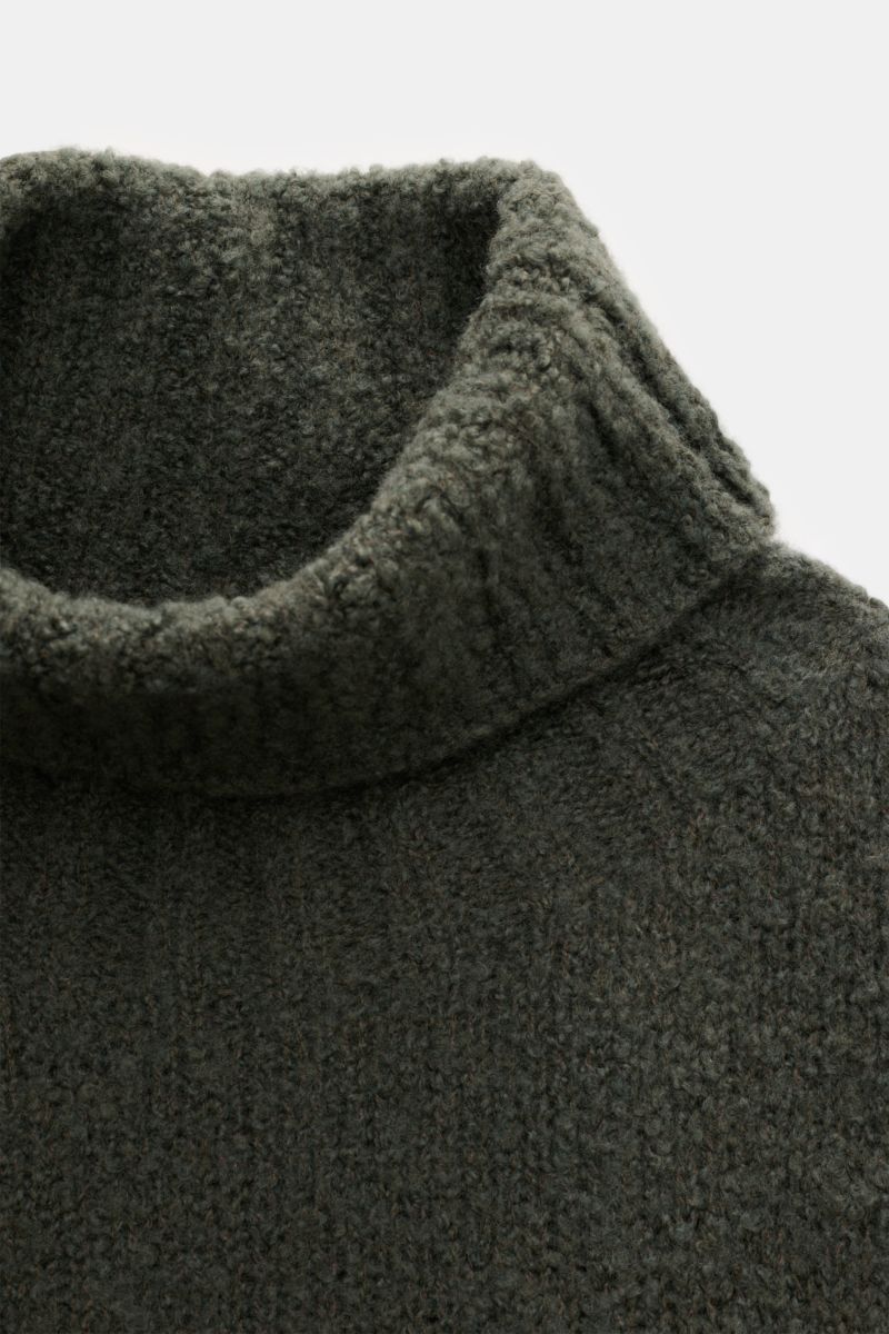 Close-up front-top view of the 04651/ A trip in a bag Rollkragenpullover 'Chunky Turtle' dunkelgrün, a chunky knit slim fit turtleneck sweater.

Edles Winter-Essential: Der legere 'Chunky Turtle' Rollkragenpullover von 04651/ A TRIP IN A BAG wird mit s