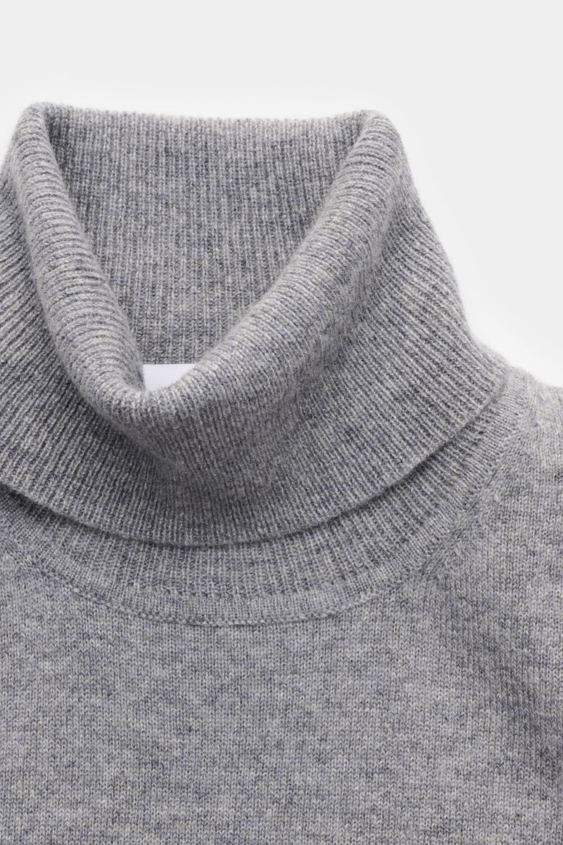 Nahaufnahme von einem von Braun Cashmere Rollkragenpullover grau meliert, fein gestrickt aus reinem Cashmere mit weichem Griff, Slim Fit, anliegendem Rollkragen und elastischen Rippbündchen, aus der Mongolei, frontal fotografiert.