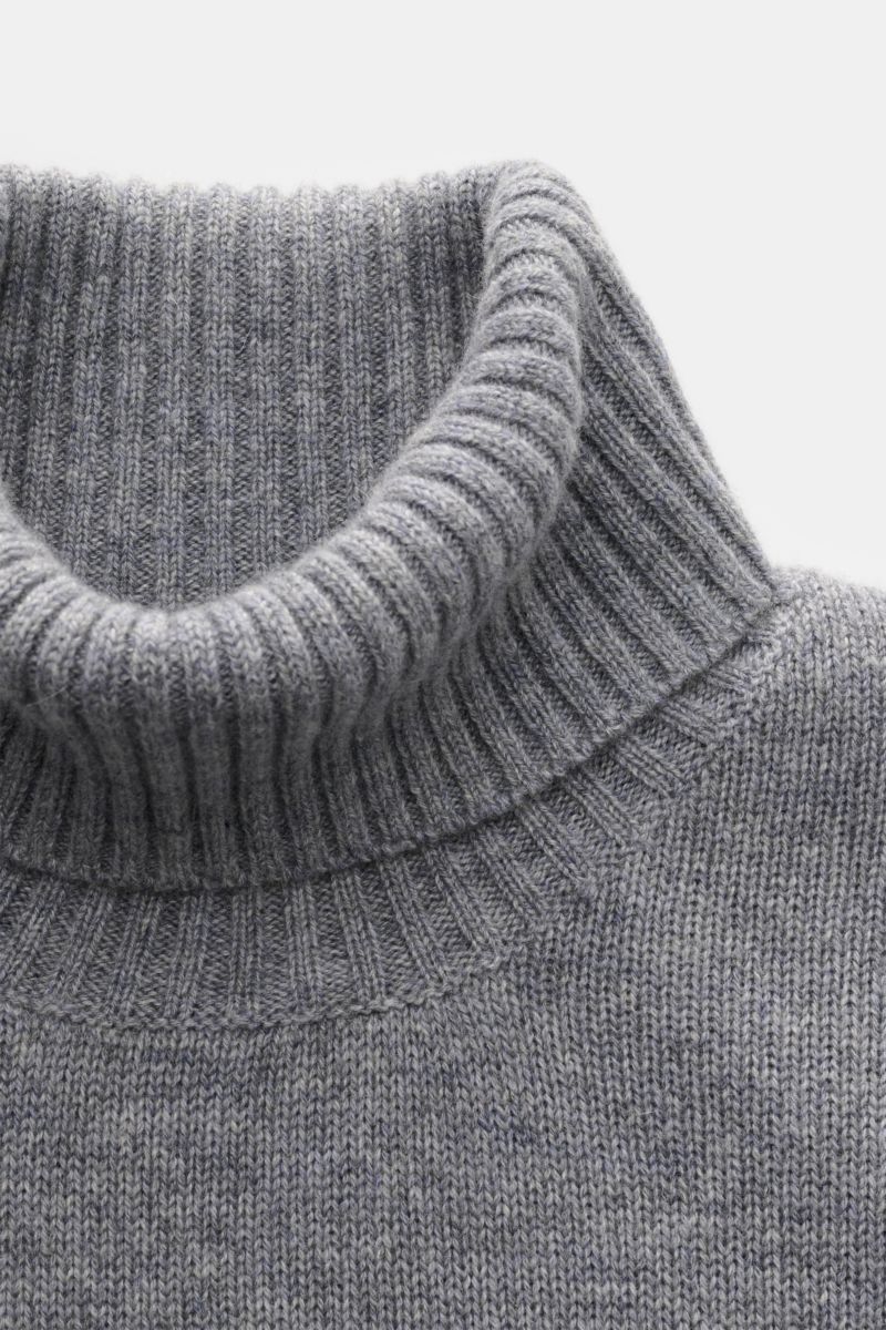 Nahaufnahme des von Braun Cashmere Rollkragenpullovers grau meliert von oben, mittelfein gestrickt mit anliegendem Rollkragen und Rippbündchen.