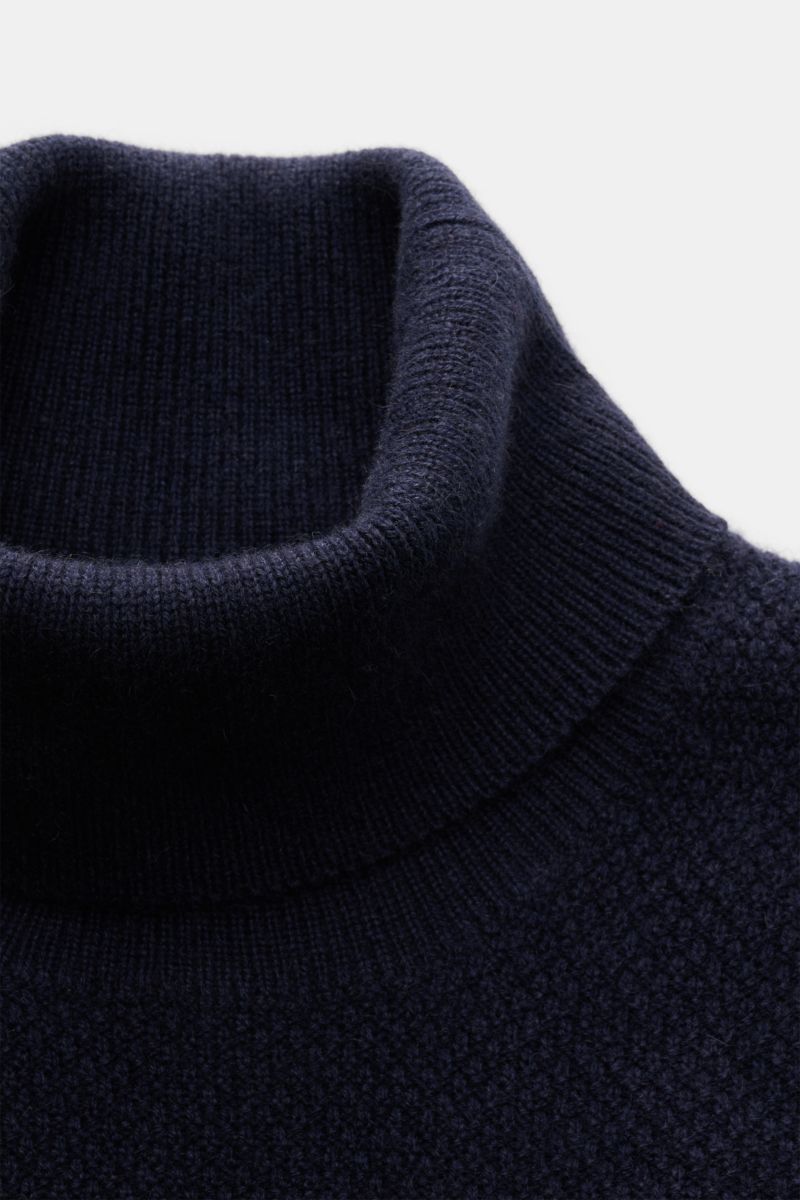 Nahaufnahme des von Braun Cashmere Rollkragenpullovers navy aus reinem mongolischem Cashmere, mittelfeiner Strukturstrick, Slim Fit, Rollkragen und Rippbündchen, seitliche Perspektive.