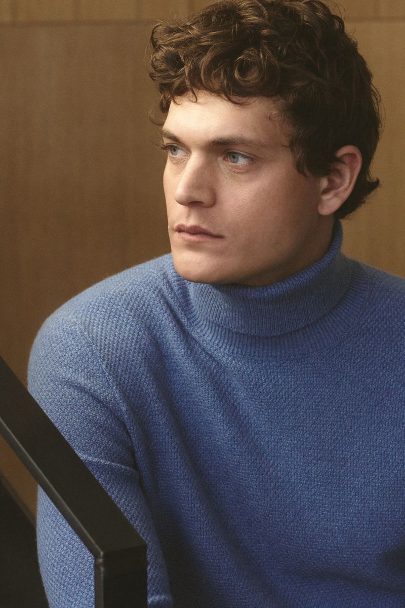 Mann im Halbprofil trägt von Braun Cashmere Rollkragenpullover blau meliert, Slim Fit, mongolischer Cashmere, Strukturstrick, Rippbündchen.